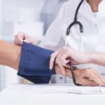 Medizinisches Fachpersonal misst den Blutdruck eines Patienten mit einem Blutdruckmessgerät